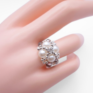 White pearl and smoky grey crystal beaded statement ring with cubic zirconia centre, displayed on a hand mannequin.