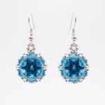 Sapphire blue and aquamarine crystal cluster earrings with silver beaded detail and silver hooks. Shown against a neutral background.