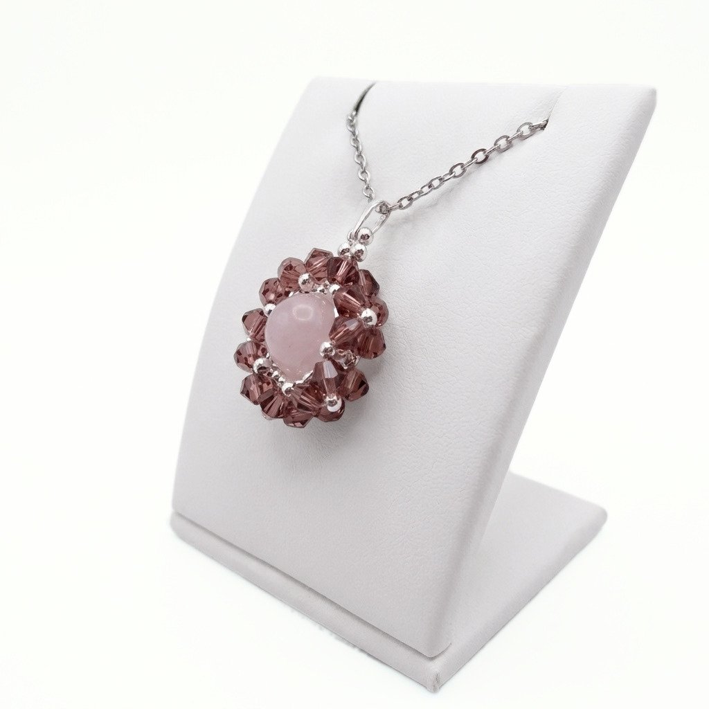 rose-quartz-flower-pendant-side-view A side view of a rose quartz and purple crystal flower pendant necklace with silver accents on silver chain - displayed on a white jewellery stand